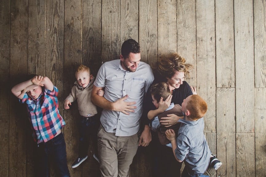 Family having fun tickling on old wood floor Family having fun tickling on old wood floor