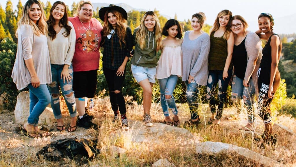 Group of young women standing together outdoors, community friendship