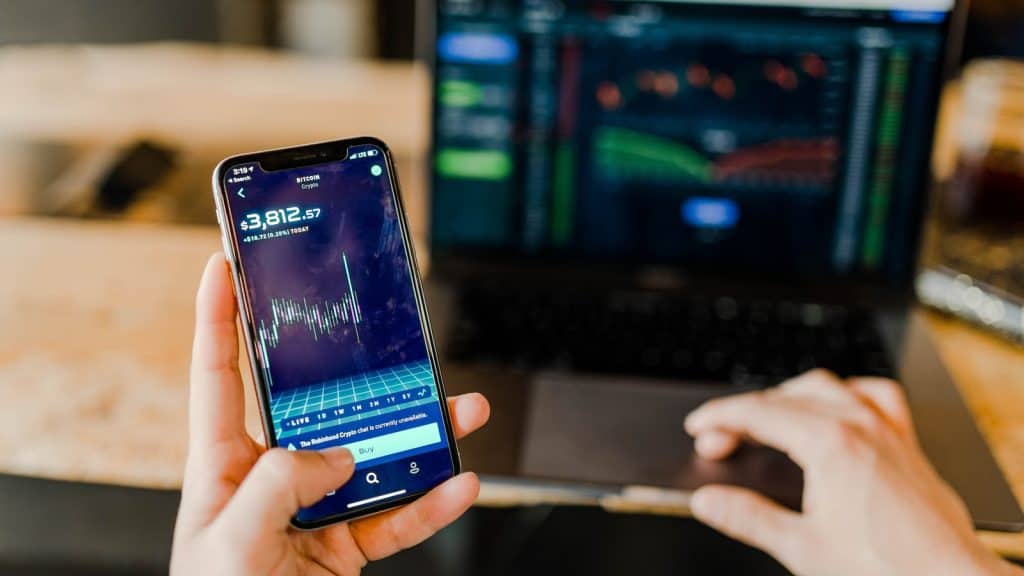 Person holding phone showing cryptocurrency app, technology finance
